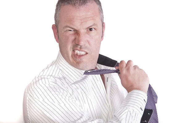 Angry frustrated stressed businessman pulls his tie off whilst m — Stock Photo, Image