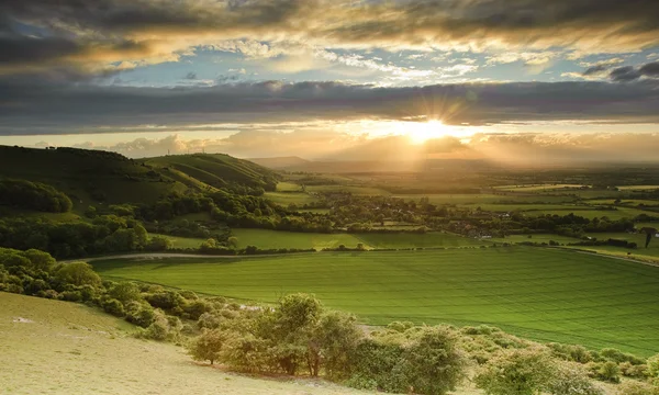 Impressionante pôr do sol verão sobre paisagem de escarpa rural — Fotografia de Stock