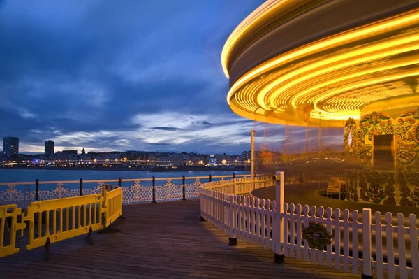Moving carousel carnival ride at sunset with motion blur — Stock Photo, Image