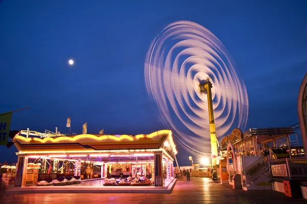 Spinning vertical ride at carnival with moving light blur — Stock Photo, Image