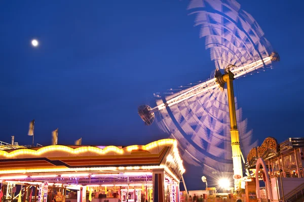 Divertido carnaval feria paseo paisaje con luces brillantes en movimiento —  Fotos de Stock