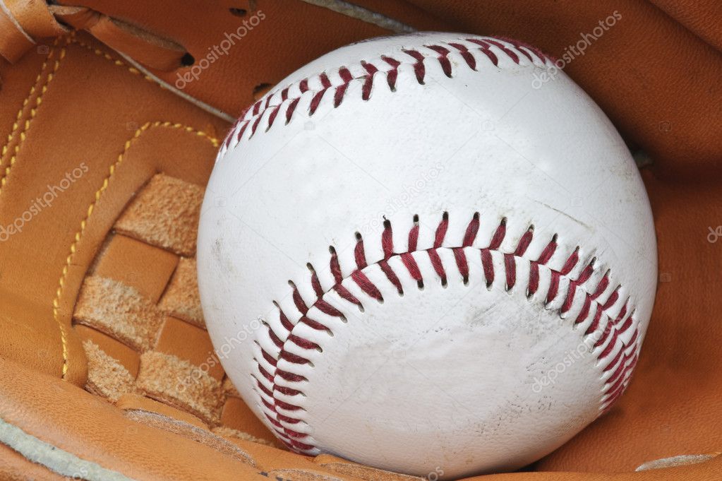 Close up of baseball in catcher's mittt with shallow depth of fi