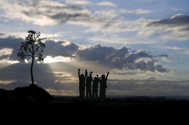 Silhouette of four young children against stunning sunset with s clipart