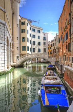 Venice Italy canal with old buildings one side and new buildings clipart