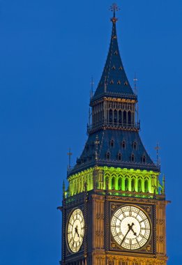 Big Ben at twilight witth lights making architecture glow in the coming dar clipart