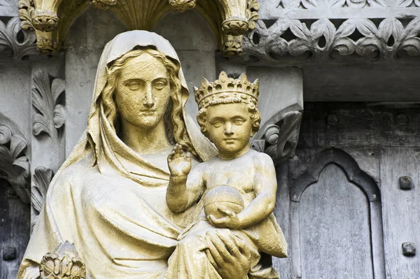 Detail close up image of Virgin Mary holding Jesus on side entrance to West — Stock Photo, Image