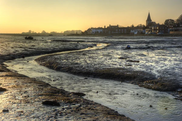 Low tide harbour at sunset with nearby town in distance nad stre — Stock Photo, Image