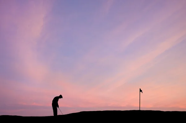 Silhueta golfista contra o deslumbrante céu do pôr-do-sol — Fotografia de Stock