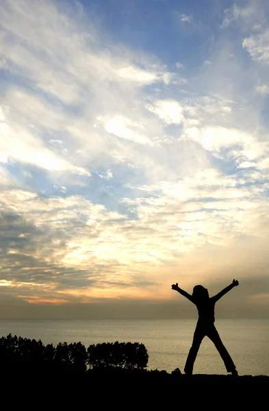 Fiatal lány boldog naplemente kinézett a tenger sziluettje — Stock Fotó