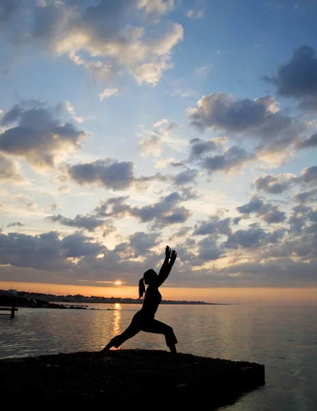 Silhouette of fit young woman doing stretching exercises on beac — Stock Photo, Image