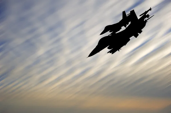 Silhouette de l'avion d'attaque militaire contre le coucher de soleil vibrant sk — Photo