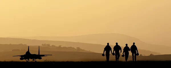 Silhuett av militär attackflygplan mot pulserande solnedgång sk — Stockfoto