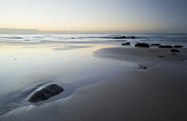 Hermosa vista de la playa al amanecer con detalles rocosos — Foto de Stock