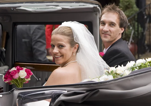 Νύφη και γαμπρός φθάνουν στη ρεσεψιόν σε vintage Στολισμός αυτοκινήτου — Φωτογραφία Αρχείου