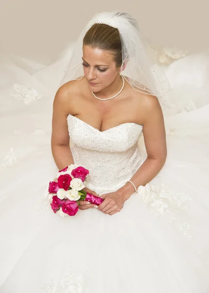 Mooi portret van aantrekkelijke jonge bruid omringd door jurk — Stockfoto