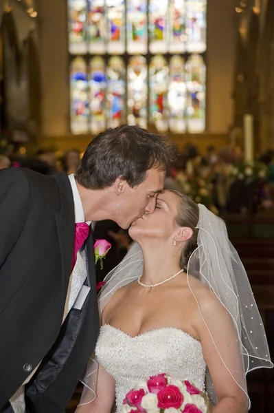 Junge attraktive Braut und Bräutigam genießen den ersten Kuss, nachdem sie — Stockfoto