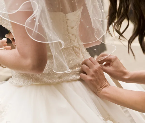 Деталь подружки невесты починки свадебного платья невесты — стоковое фото