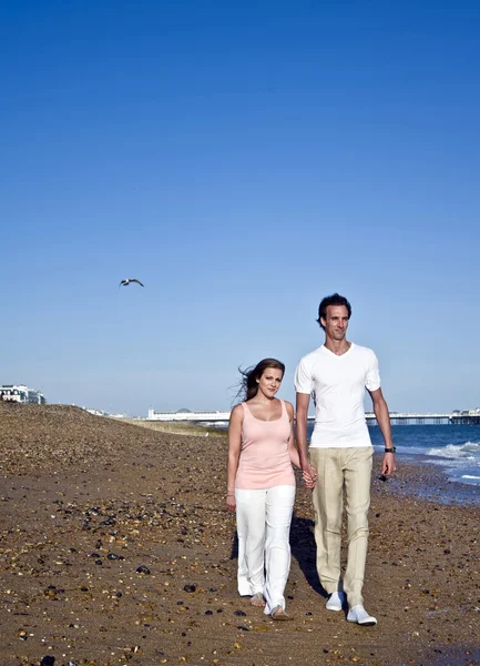 Молодая привлекательная пара на пляже в летнее солнце — стоковое фото