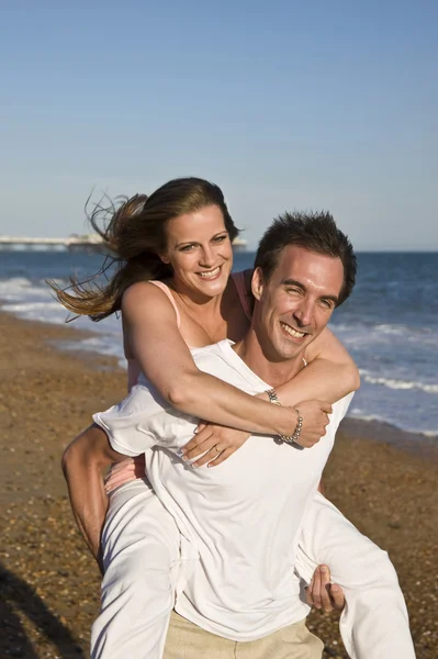 Mladý atraktivní pár na pláži v letním slunci — Stock fotografie