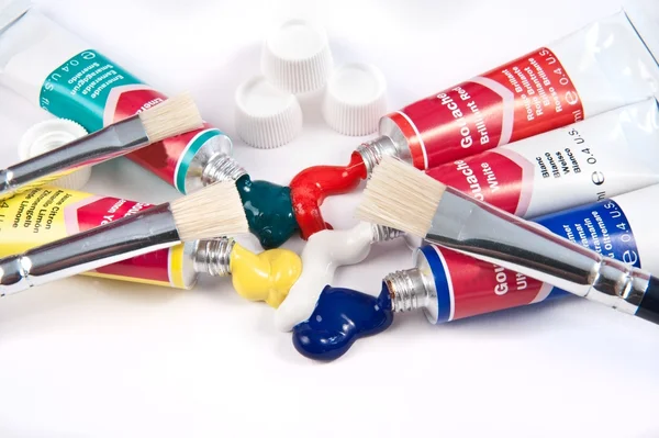 Red white and blue acrylic paint tubes and paint brushes — Stock Photo, Image