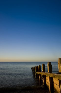 ahşap groyne iskelesi ile pürüzsüz deniz üzerinde huzurlu gündoğumu