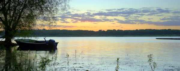 Połów Łódka po jeziorze spokój podczas Letnich wibrujący zachód słońca — Zdjęcie stockowe
