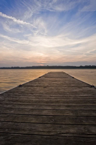 Dlouhé dřevěné molo pier v klidné jezero během letní slunce — Stock fotografie