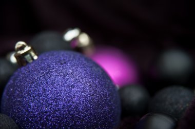 Unusual purple Christmas decorations against black background wi clipart