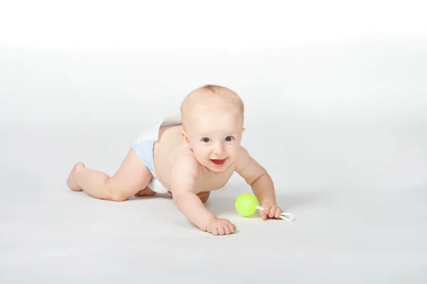 Baby von sechs Monaten mit Spielzeug auf weißem Hintergrund — Stockfoto