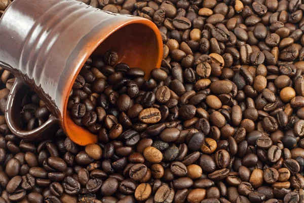 Grãos de café caindo de uma xícara de café — Fotografia de Stock