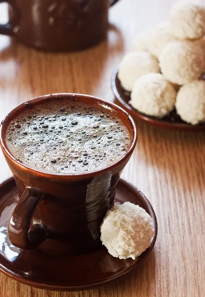 Cup of coffee and white chocolate truffles on table — Stock Photo, Image