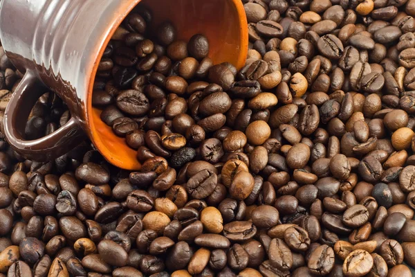 Кавові зерна падають з чашки кави — стокове фото