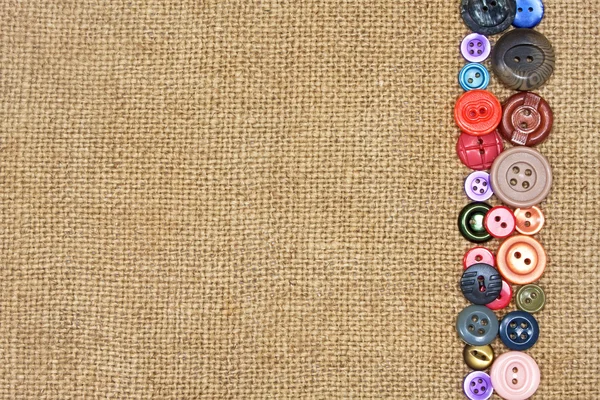 Régi színes gombok a háttérben zsákvászon오래 된 다채로운 단추 — Stock Fotó
