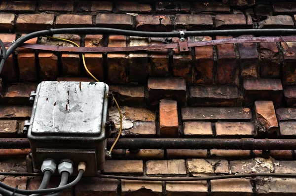 Электрическая коробка на заброшенной кирпичной стене — стоковое фото
