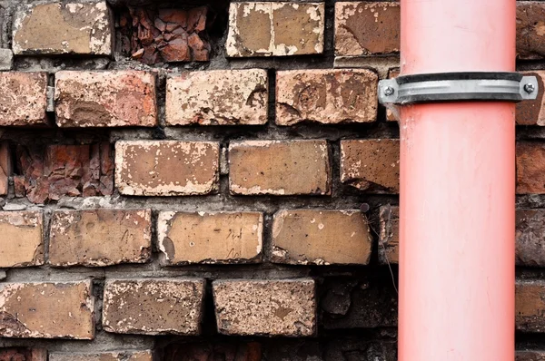 Tubo de drenagem contra parede de tijolo — Fotografia de Stock