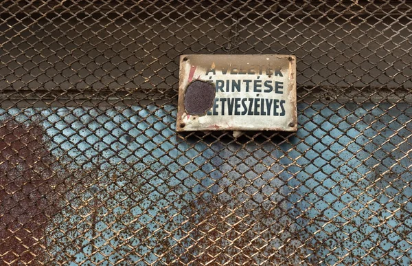 Gevaar! hoogspanning teken op metalen hek — Stockfoto