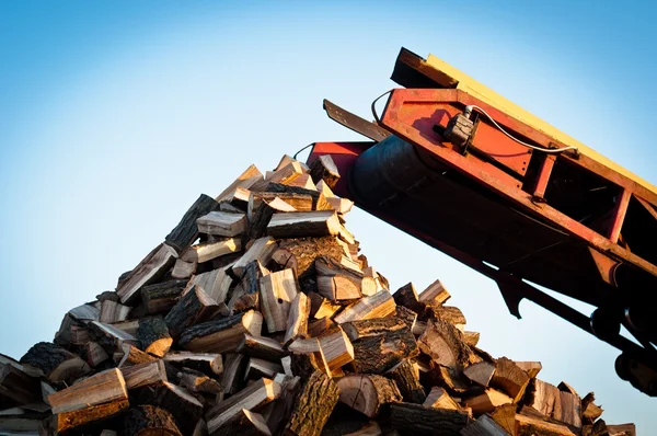 Brandhout komt uit een machine — Stockfoto