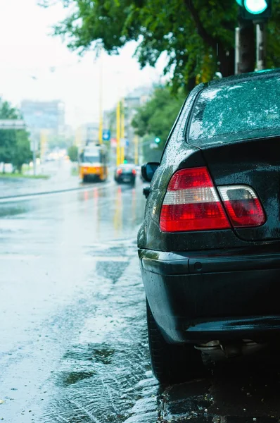 Närbild skott av en parkering bil i regnet med suddiga bakgrunden — Stockfoto