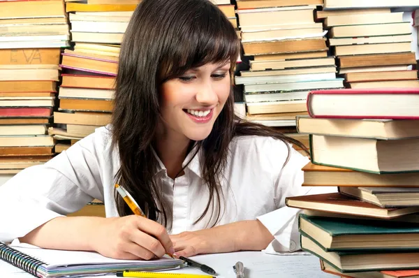 Menina estudante atraente escrevendo seu dever de casa — Fotografia de Stock