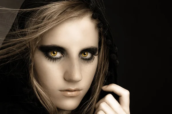 Ein attraktives schönes Mädchen mit Kapuze vor schwarzem Hintergrund — Stockfoto
