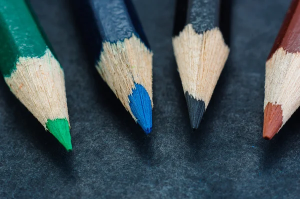Dizilmiş koyu arka plan üzerinde renkli kalemler — Stok fotoğraf
