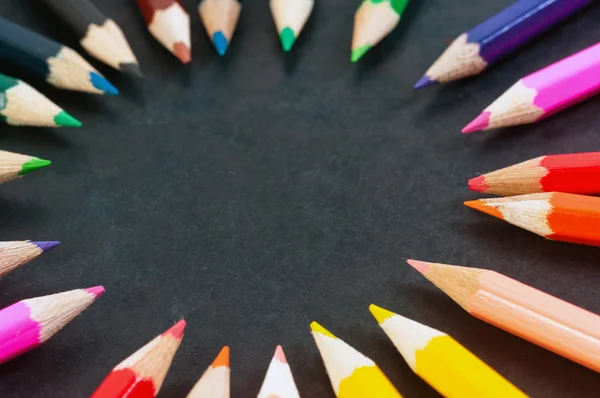 Красочные карандаши на темном фоне в круге — стоковое фото
