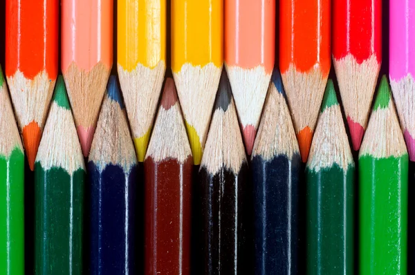 Dizilmiş koyu arka plan üzerinde renkli kalemler — Stok fotoğraf