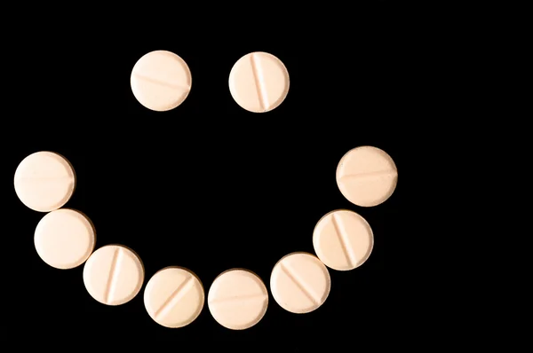 stock image Smiling face made out of pills on black background