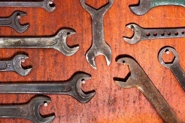 Używane klucze na czerwony deska drewniany — Zdjęcie stockowe
