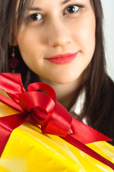 Christmas present with a beautiful girl in the background — Stock Photo, Image
