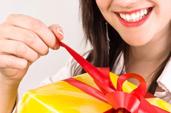 Attractive girl with a cheerful expression opening her christmas — Stock Photo, Image