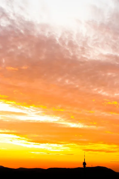 Solnedgång med orange moln och silhuetten av bergen — Stockfoto