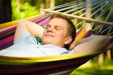 Young man sleeping in a hammock clipart