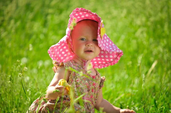 Schattige kleine baby zitten in het gras — Stockfoto